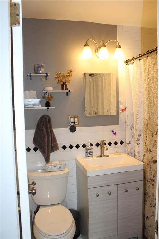 12399 Flatlands Ave Unit 6L, Brooklyn, NY 11207 - bathroom featuring toilet, tile walls, wainscoting, and vanity