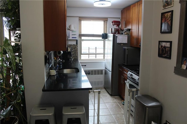 12399 Flatlands Ave Unit 6L, Brooklyn, NY 11207 - kitchen with a sink, radiator heating unit, a healthy amount of sunlight, and gas stove
