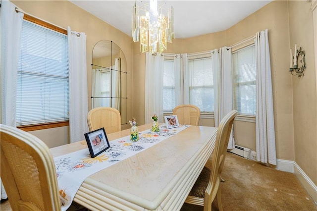 dining space featuring a chandelier, a baseboard heating unit, carpet flooring, and baseboards