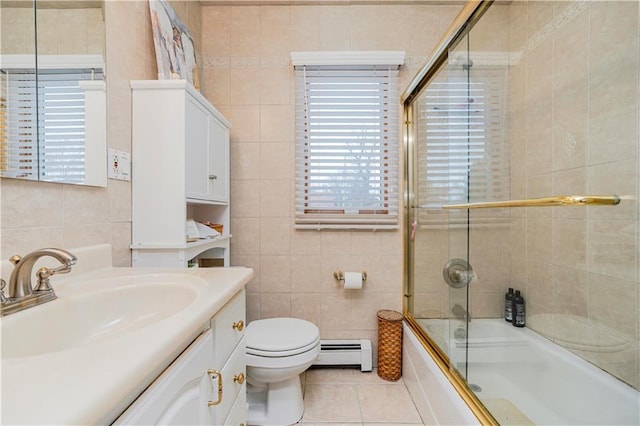 full bathroom featuring tile walls, a baseboard heating unit, vanity, bath / shower combo with glass door, and tile patterned floors