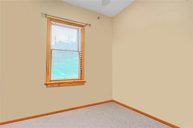 carpeted empty room featuring baseboards and a ceiling fan