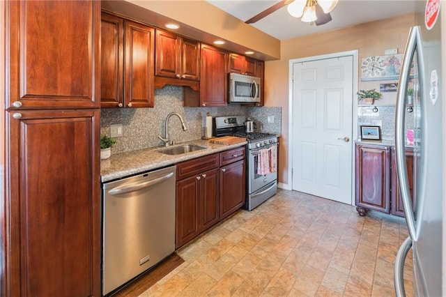 96 Lamped Loop Unit 2, New Springville, NY 10314 - kitchen featuring stainless steel appliances, a sink, backsplash, a ceiling fan, and light stone counters
