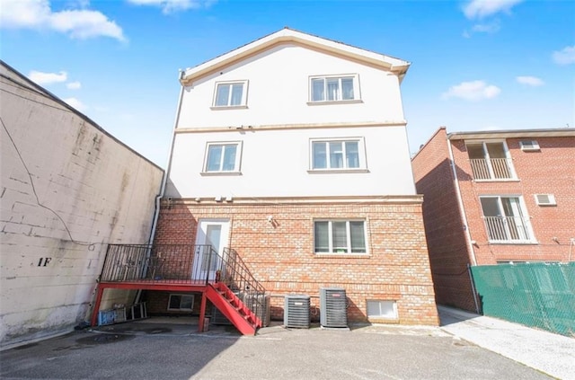 2841 Ford St Unit 1R, Brooklyn, NY 11235 - back of house featuring brick siding, stucco siding, and central air condition unit