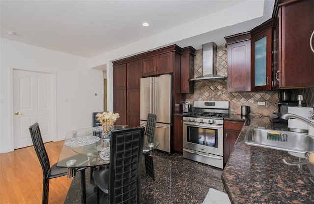 2841 Ford St Unit 1R, Brooklyn, NY 11235 - kitchen with wall chimney range hood, appliances with stainless steel finishes, a sink, tasteful backsplash, and glass insert cabinets