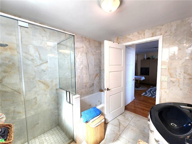 129 W End Ave Unit 3B, Brooklyn, NY 11235 - full bathroom featuring a whirlpool tub, a shower stall, tile walls, and tile patterned floors