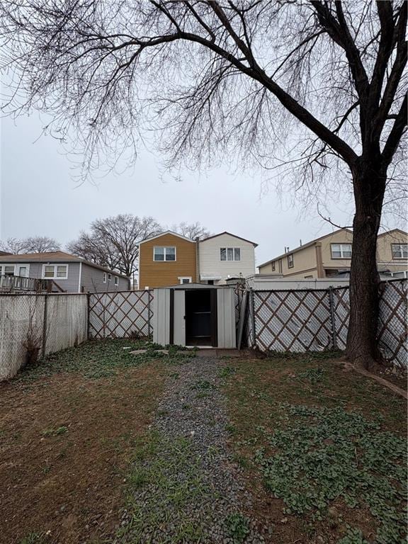 view of yard with a fenced backyard, a storage unit, and an outdoor structure