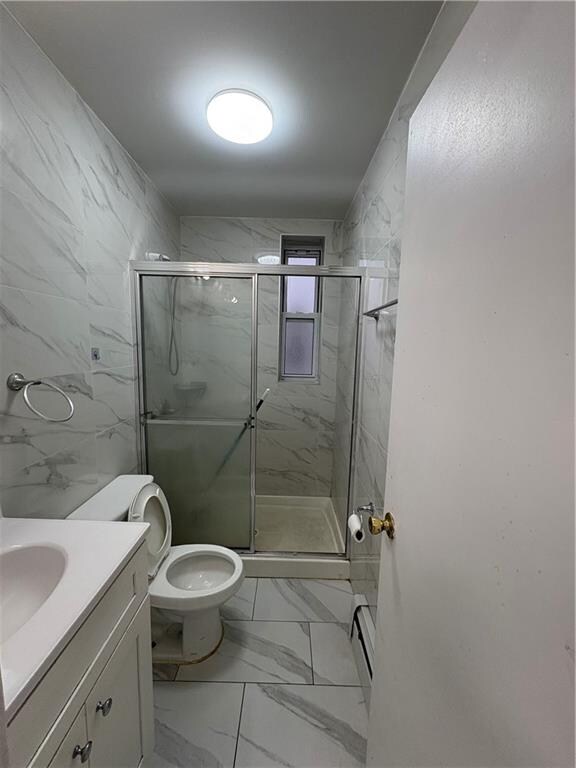 full bathroom with vanity, marble finish floor, a stall shower, and toilet