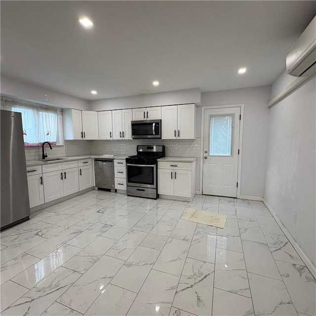 kitchen with appliances with stainless steel finishes, a sink, light countertops, baseboards, and tasteful backsplash