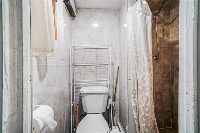 bathroom featuring tile walls, a stall shower, and toilet