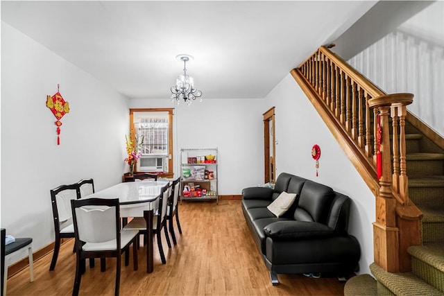 dining space featuring a chandelier, stairway, light wood-style floors, and baseboards