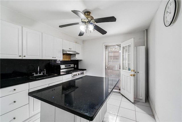 kitchen with white cabinetry, a sink, under cabinet range hood, and gas stove