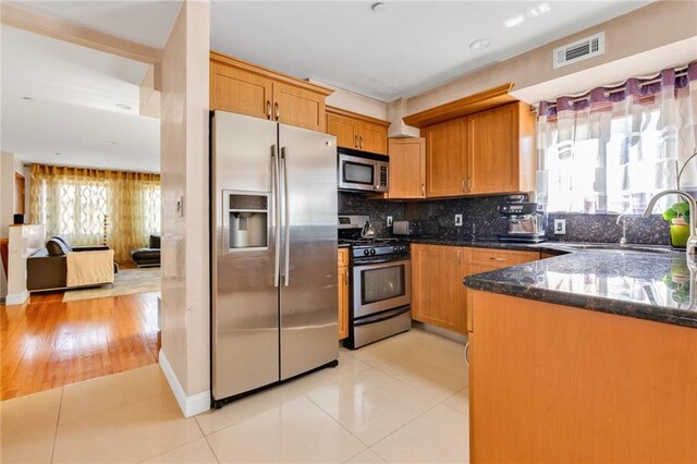 kitchen with visible vents, dark stone countertops, appliances with stainless steel finishes, and light tile patterned floors