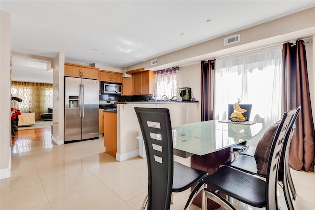 dining area featuring light tile patterned flooring and visible vents