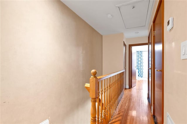 corridor featuring an upstairs landing, visible vents, attic access, and light wood finished floors