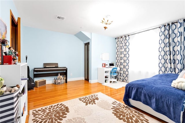 bedroom featuring baseboards, visible vents, and light wood finished floors