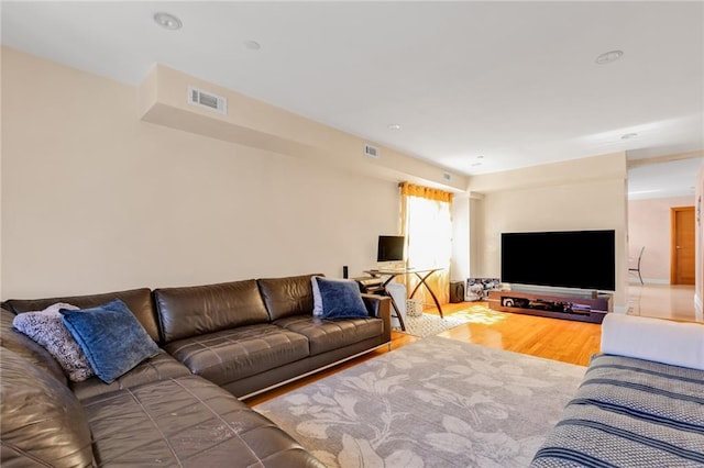 living area with visible vents and wood finished floors