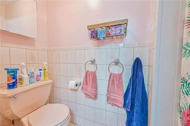 full bath with a shower with shower curtain, tile walls, and toilet