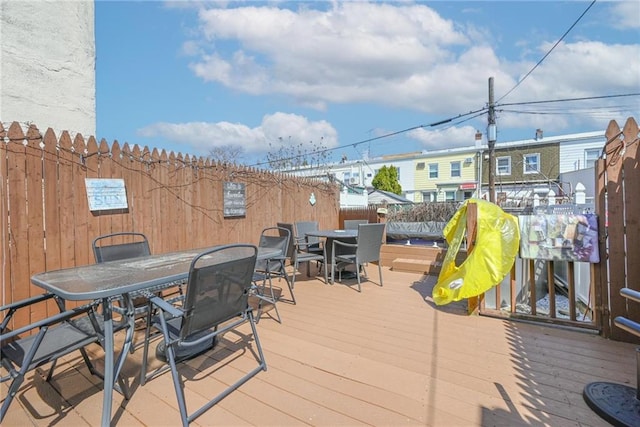 wooden terrace with outdoor dining space and fence