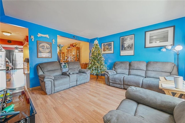 living area with ceiling fan and wood finished floors