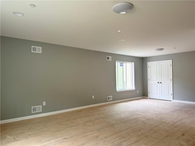 spare room with baseboards, visible vents, and light wood-style flooring