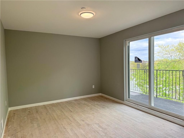 spare room featuring light wood-style floors, baseboards, and visible vents