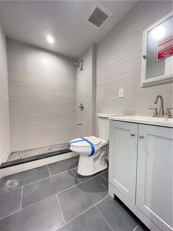 800 5th Ave Unit 4A, Brooklyn, NY 11232 - bathroom with tile patterned floors, toilet, a tile shower, visible vents, and vanity