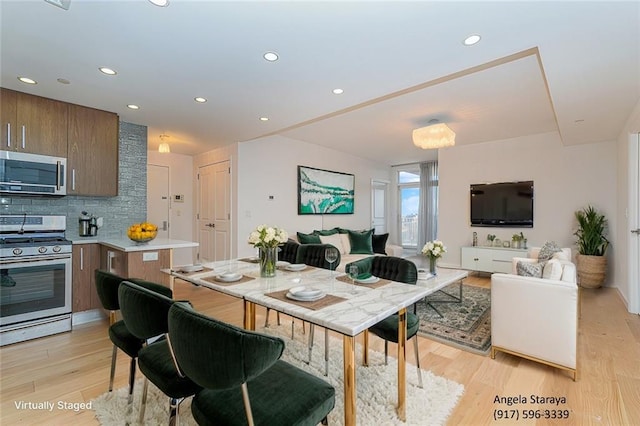 dining area featuring light wood-style flooring and recessed lighting