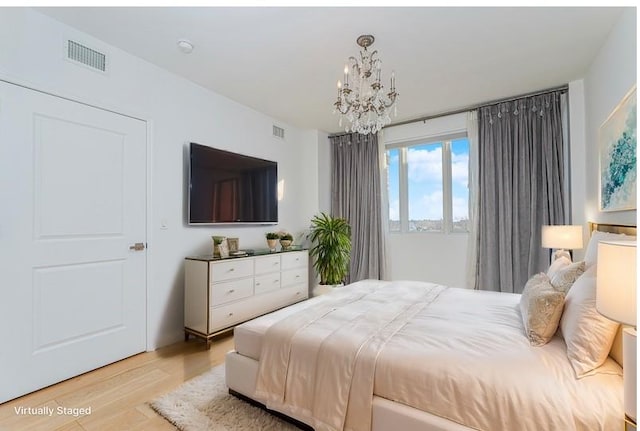 bedroom featuring a chandelier and light wood-style flooring