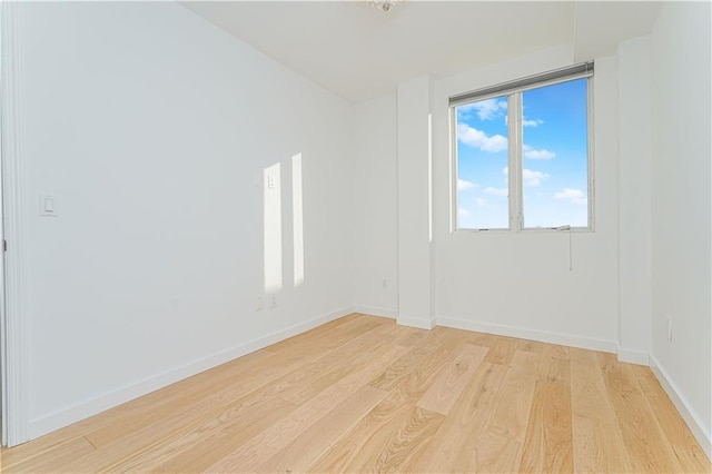 empty room featuring light wood finished floors and baseboards