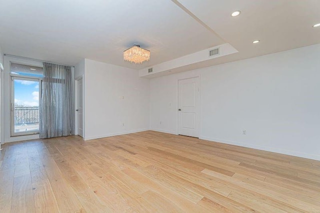 empty room featuring light wood-style floors, baseboards, and recessed lighting