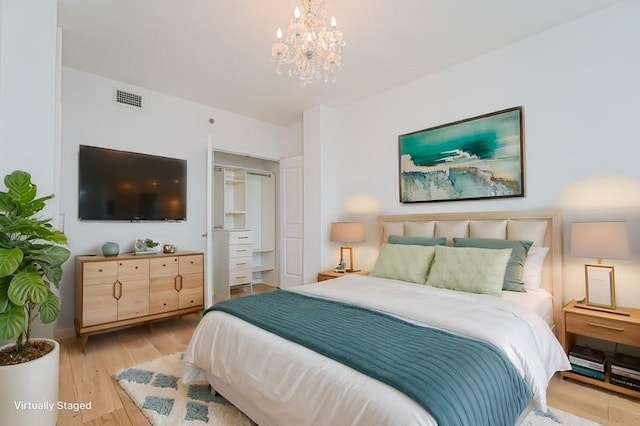 bedroom featuring light wood-style flooring and a chandelier