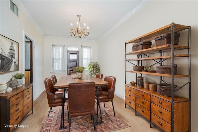 dining room with visible vents, light wood-type flooring, and crown molding