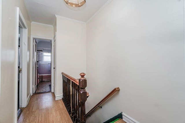 hall with crown molding, an upstairs landing, light wood-style flooring, and baseboards
