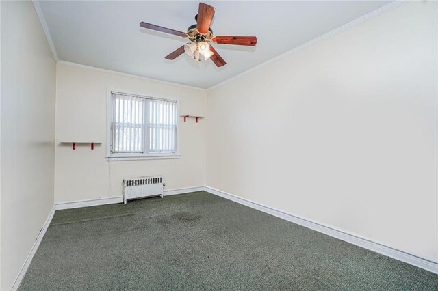 spare room featuring dark carpet, baseboards, ornamental molding, radiator heating unit, and a ceiling fan