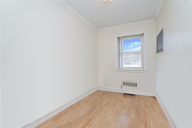 unfurnished room featuring radiator heating unit, ornamental molding, light wood finished floors, and baseboards