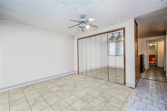 unfurnished bedroom with a closet, ceiling fan, and baseboards