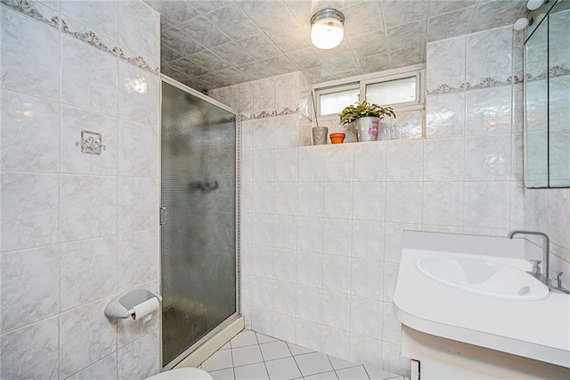bathroom with tile patterned floors, a stall shower, and tile walls