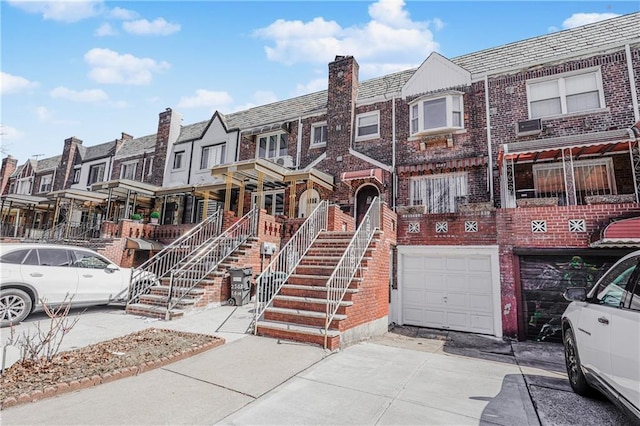 2567 E 6th St, Brooklyn, NY 11235 - view of property with brick siding, driveway, an attached garage, and a residential view
