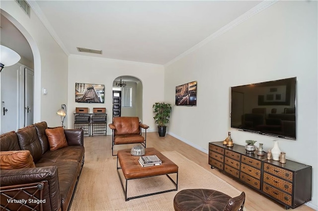 living room featuring visible vents, ornamental molding, and arched walkways