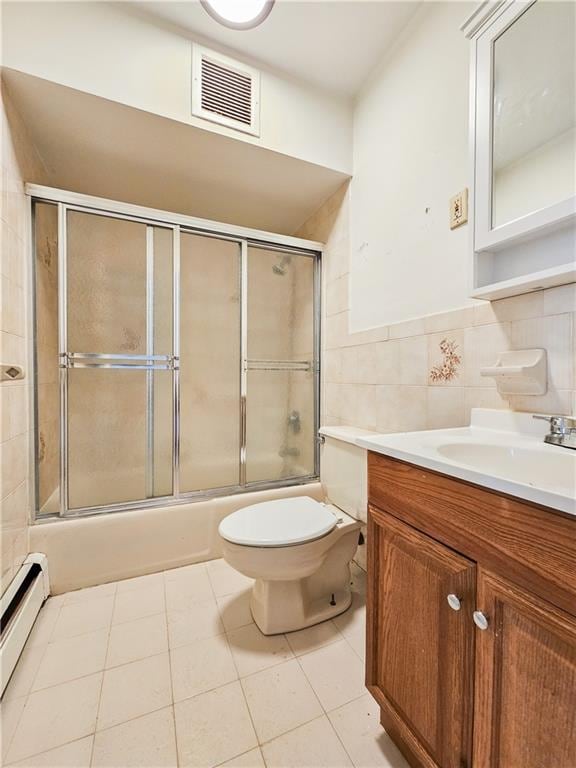 bathroom featuring visible vents, tile walls, vanity, toilet, and shower / bath combination with glass door
