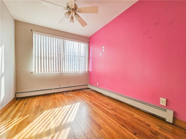 unfurnished room with a ceiling fan, baseboard heating, and hardwood / wood-style floors