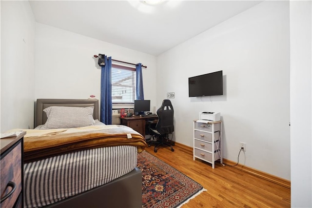 bedroom featuring wood finished floors and baseboards