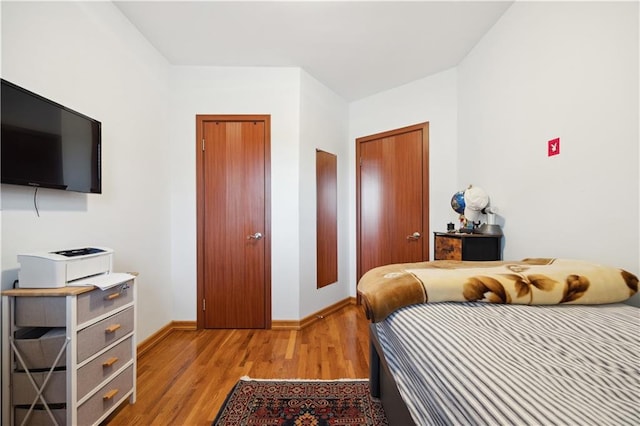 bedroom featuring baseboards and light wood finished floors