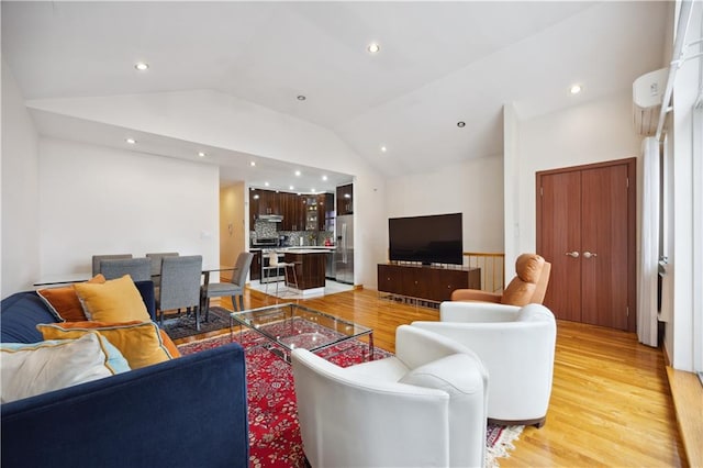 living room featuring recessed lighting, light wood finished floors, and vaulted ceiling