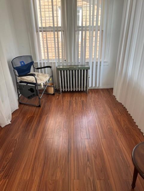 sitting room with radiator heating unit and wood finished floors