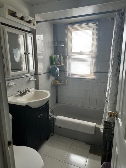bathroom with toilet, vanity, tile patterned floors, and shower / tub combo with curtain
