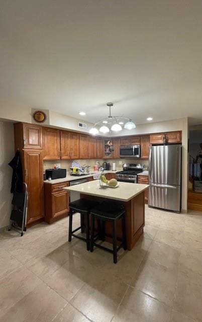 20 Linda Ln, Staten Island, NY 10312 - kitchen with visible vents, a center island, light countertops, brown cabinets, and stainless steel appliances