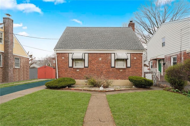 95 Bryson Ave, Staten Island, NY 10302 - view of front facade with a shingled roof, brick siding, a chimney, and a front lawn