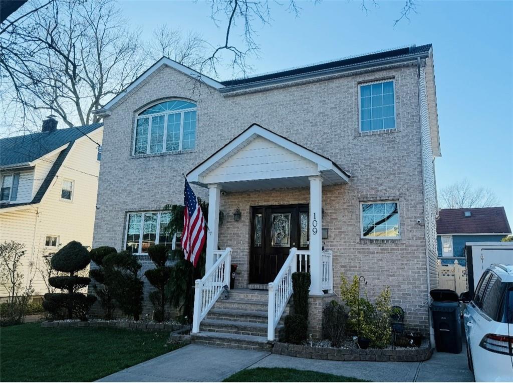 view of front of house featuring brick siding and a porch