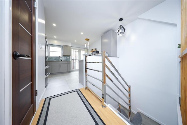 corridor featuring a sink, recessed lighting, and baseboards